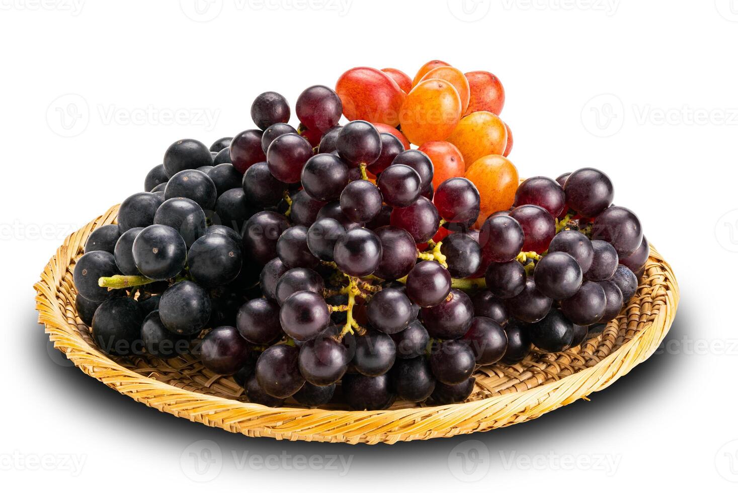 Bunches of ripe red grapes, black grapes and purple grapes in bamboo plate isolated on white background with clipping path. photo