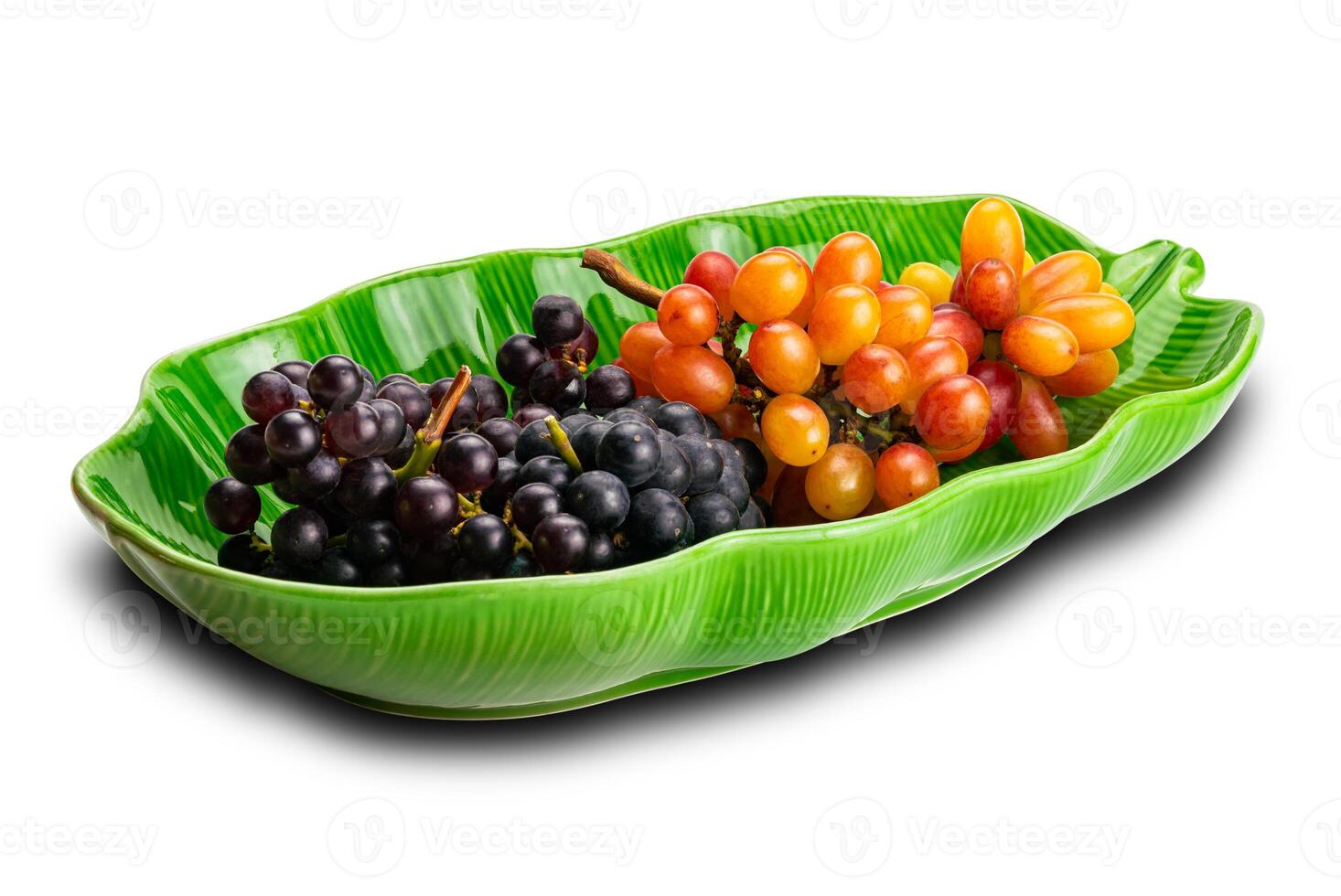 Bunches of ripe red grapes, black grapes and purple grapes in green ceramic plate isolated on white background with clipping path. photo