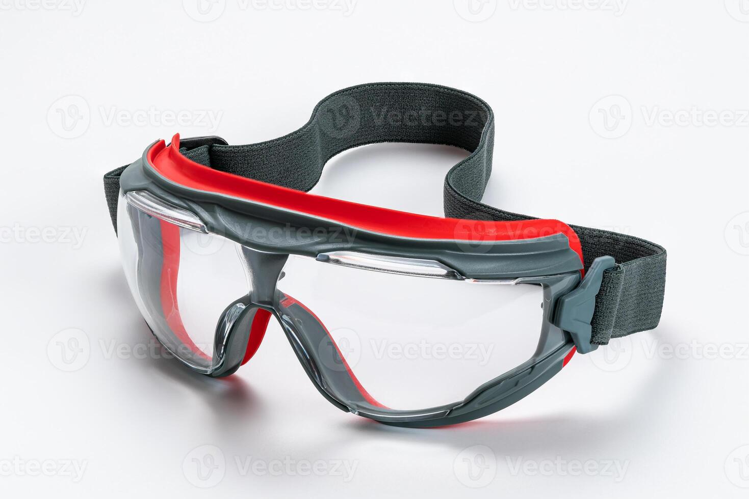 Closeup view of gray and red frame with clear polycarbonate lens goggles on white background contain clipping path. photo