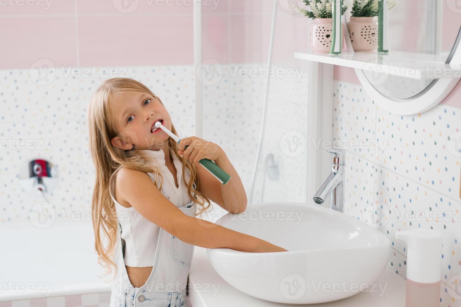 Cute girl brushes her teeth in the bathroom hygiene concept photo