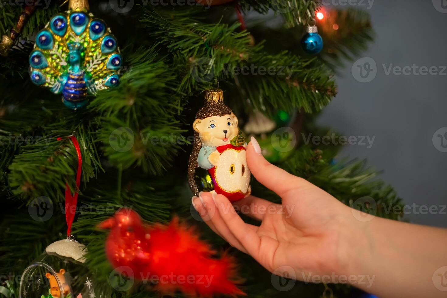 Decorating Christmas tree, close up, copy space. Merry Christmas and Happy New Year. Women hands decorate the Christmas tree with balls and toys photo