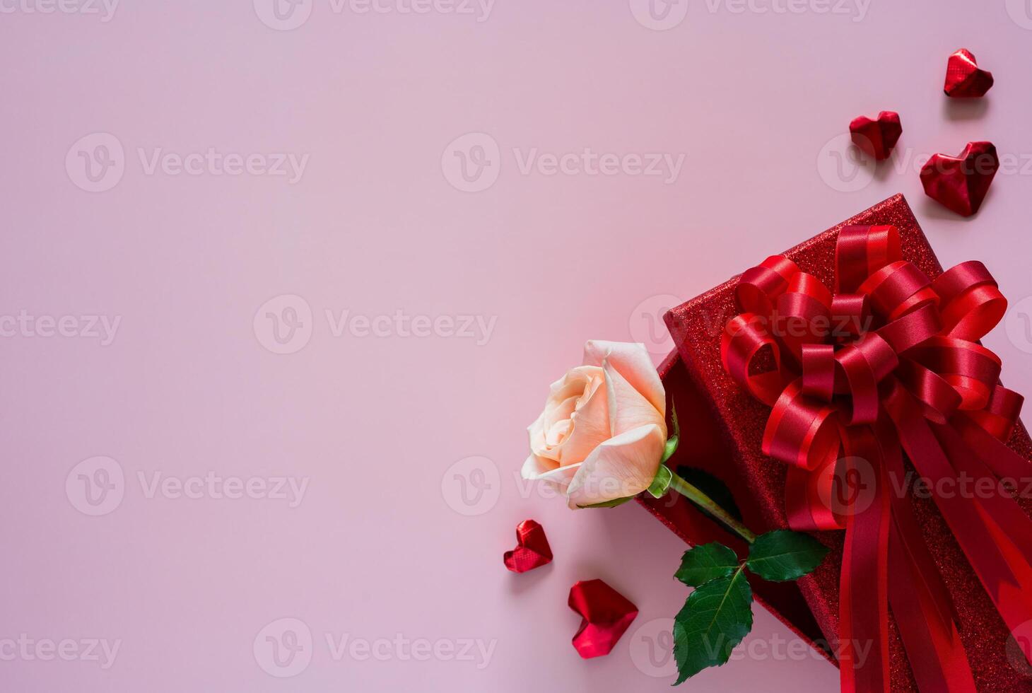 Pink rose in red gift box with love shape on pink background for Valentines day concept. photo