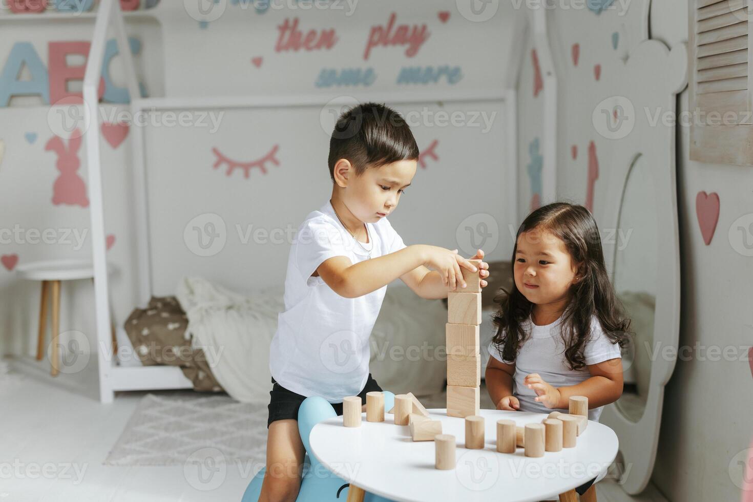 niños chico y niña jugar con de madera juguetes a hogar en para niños dormitorio foto