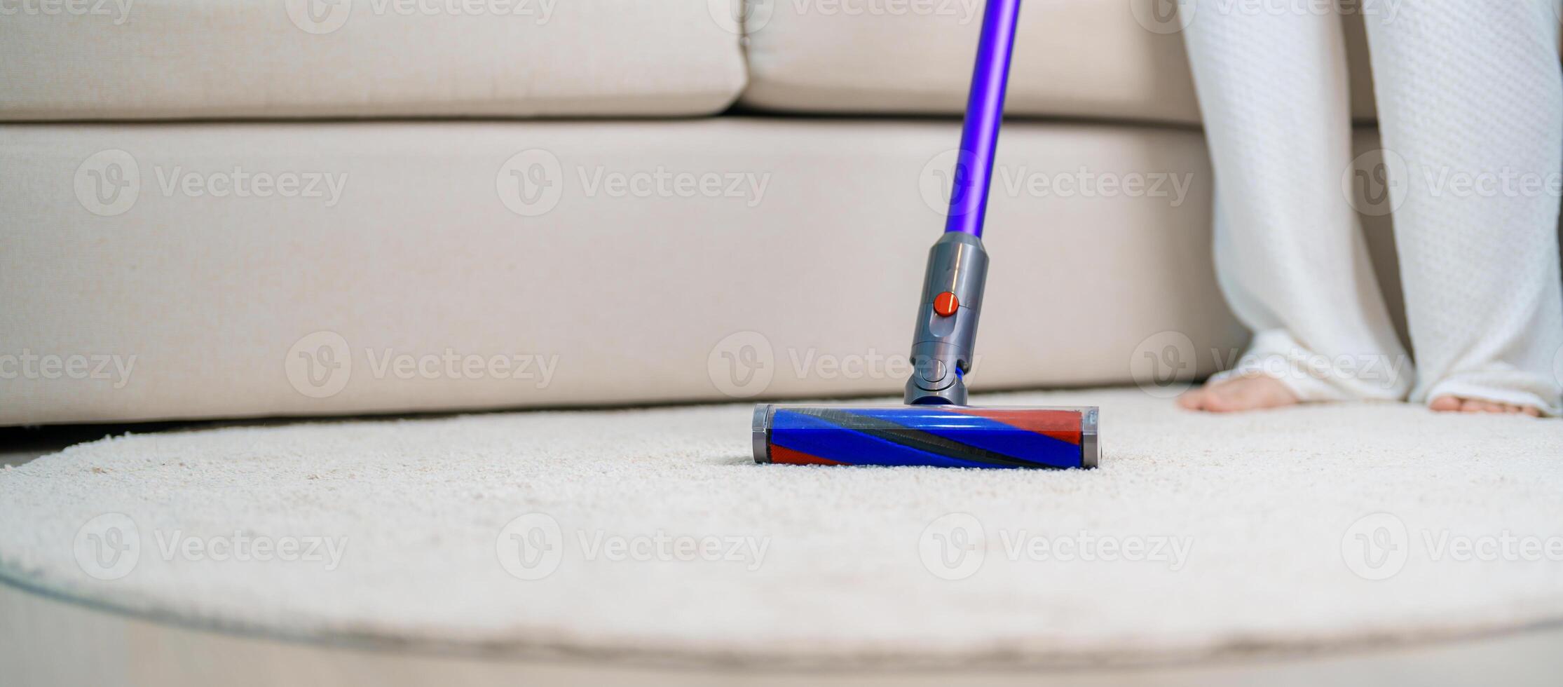 Woman cleaning Carpet with cordless Vacuum cleaner. Housewife using wireless Hoover for big cleaning home. Housework, Housecleaning, Housekeeping, Removes dust, Domestic hygiene and daily routine photo