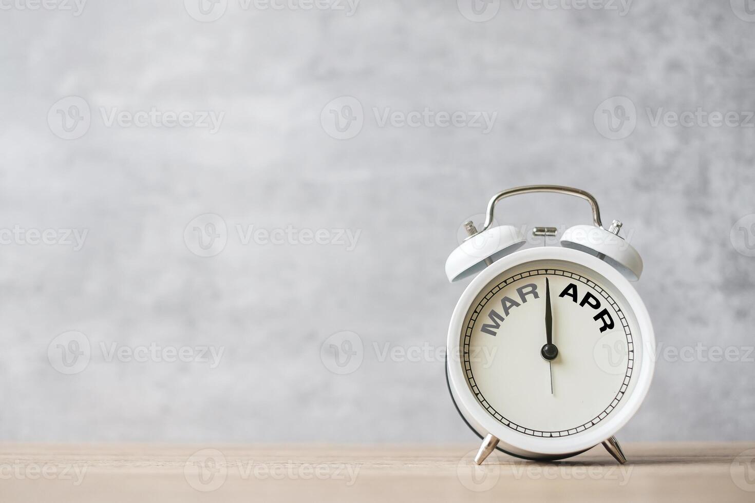 Hello April Changed from March month with vintage alarm clock on table background. Calendar, Monthly, New Start, Resolution, Goals, Plan, Action and Mission Concept photo