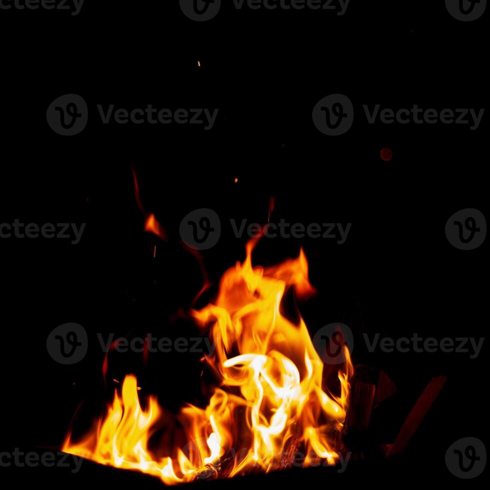 Tongues of fire at night. Bonfire burns on a black background photo