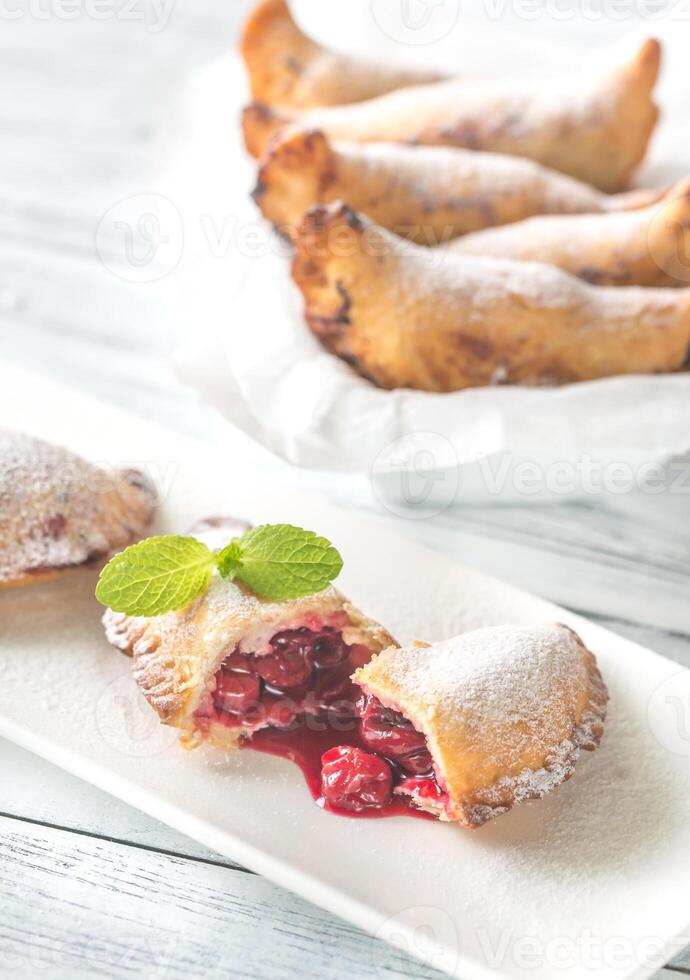 Cherry empanadas on the white plate photo