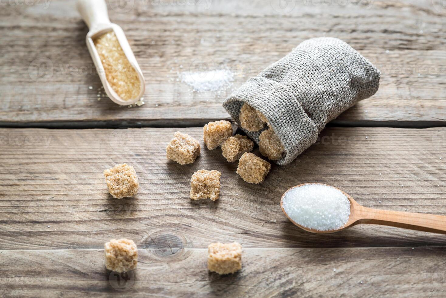 Brown and white sugar on the wooden background photo