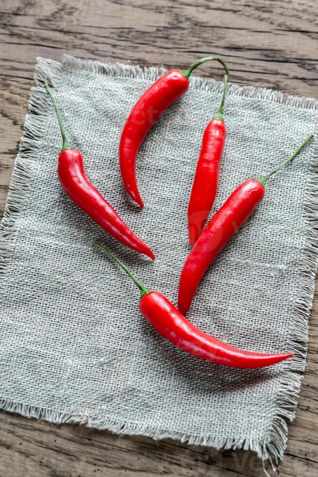 Stack of fresh red chili peppers on the burlap photo