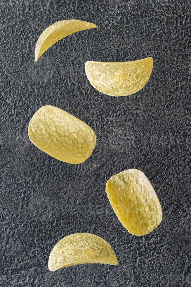 Potato chips on the black background photo