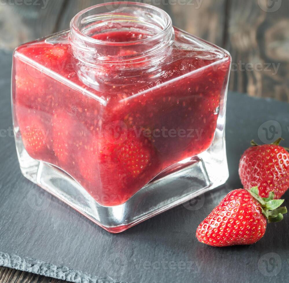 Glass jar of strawberry jam photo