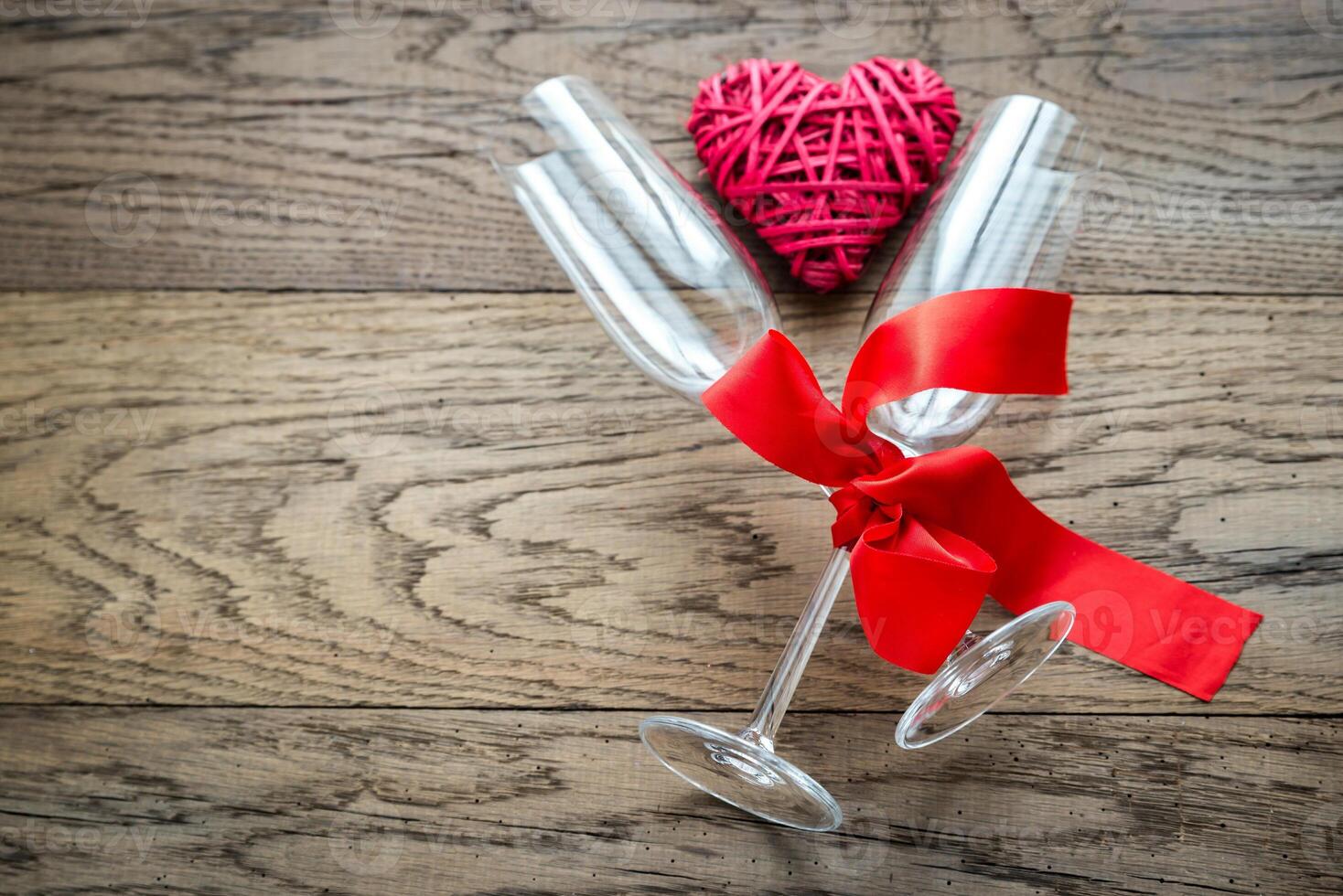 Two flutes with retro cane hearts on the wooden background photo