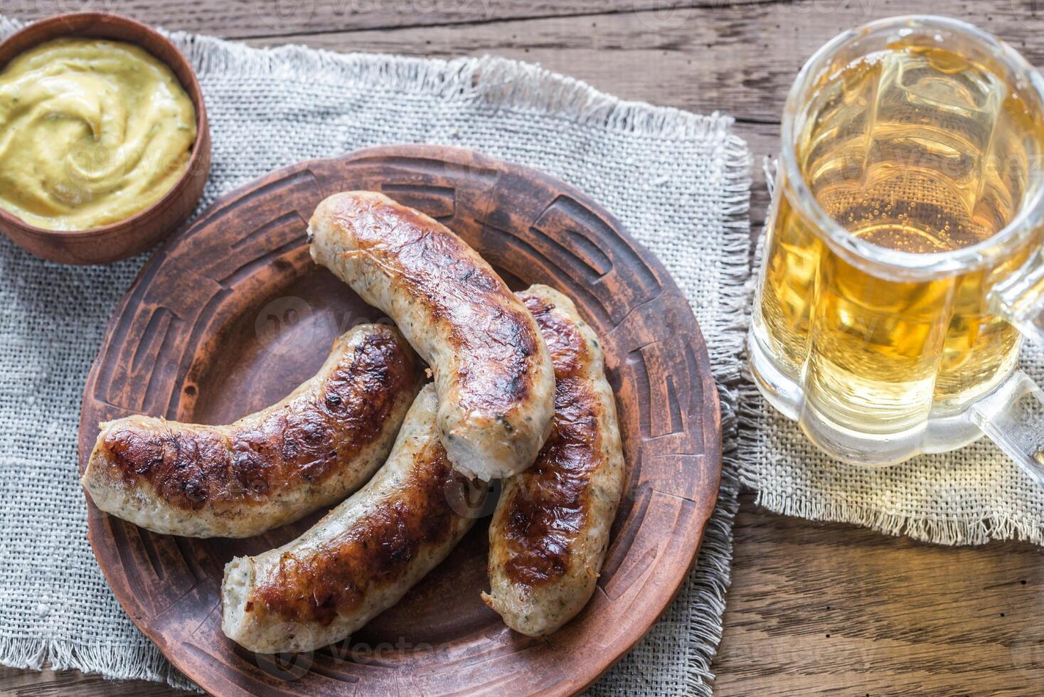 Grilled sausages with fried bacon rashers and mushrooms photo