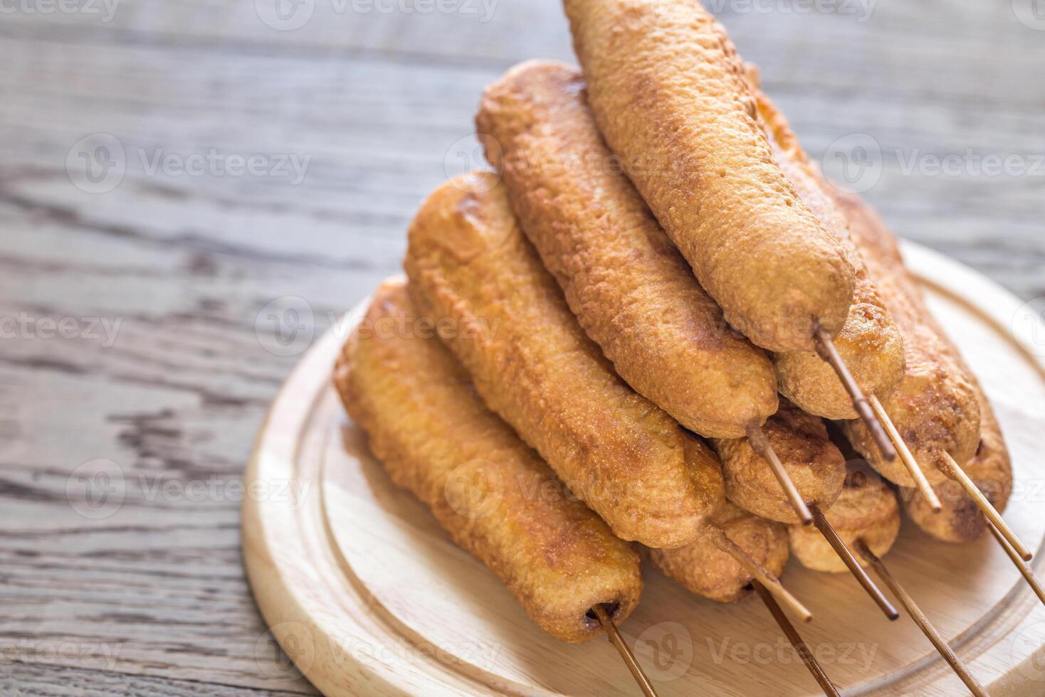 Stack of corn dogs on the wooden board photo