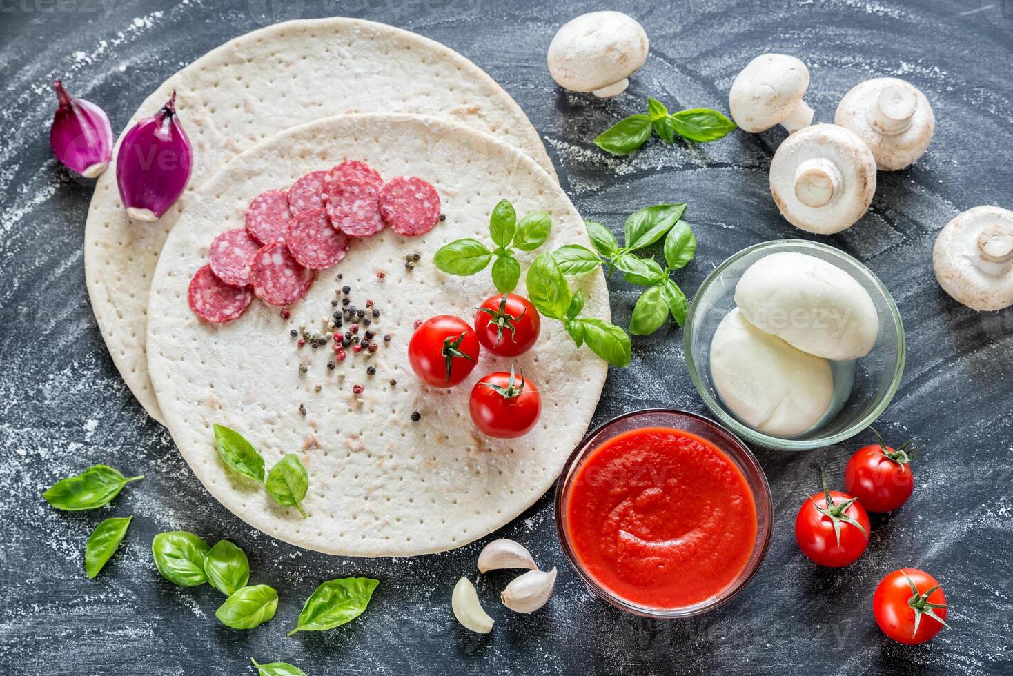 Pizza ingredients on the dark wooden background photo