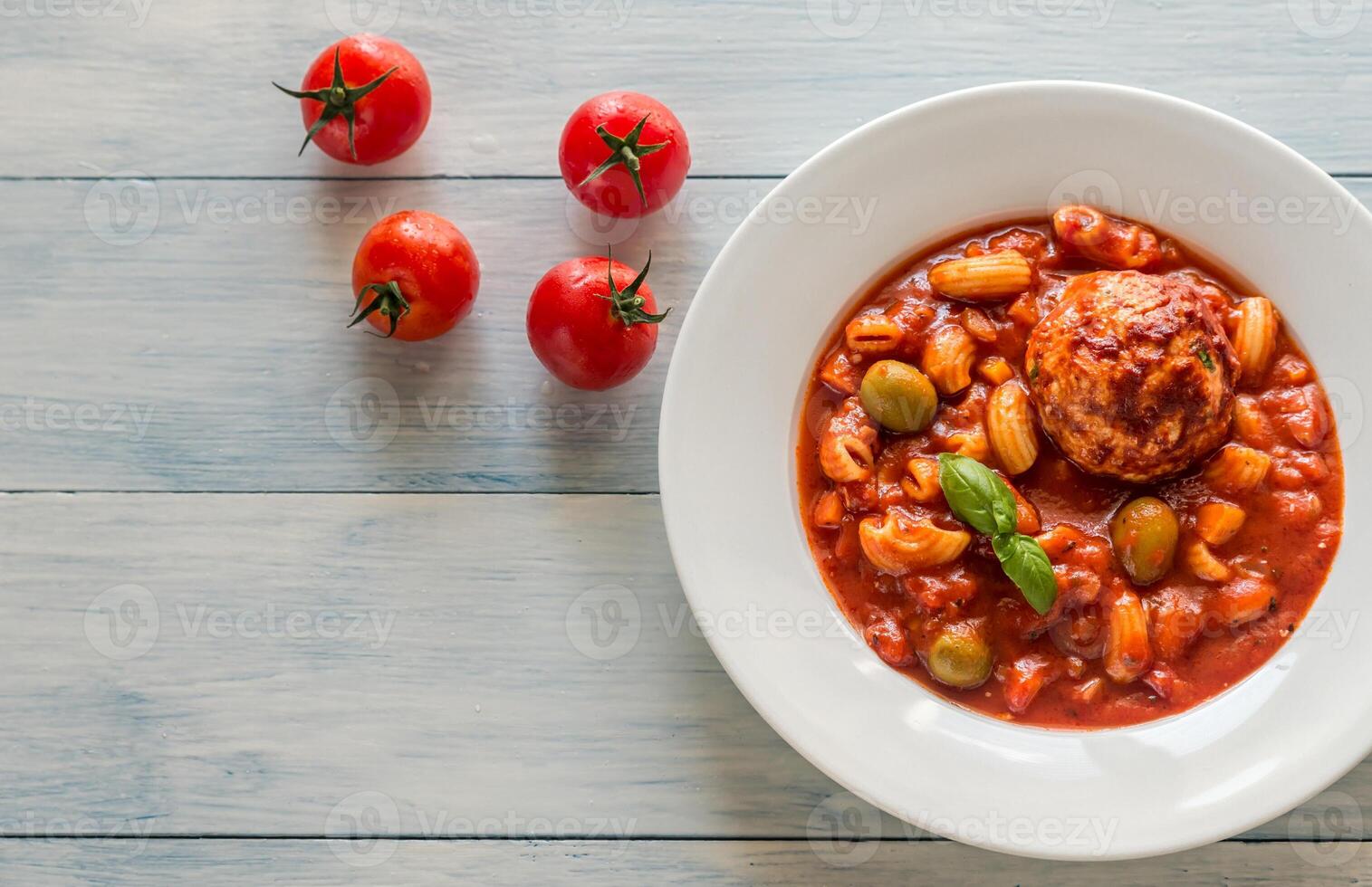 Portion of minestrone soup with meatball photo
