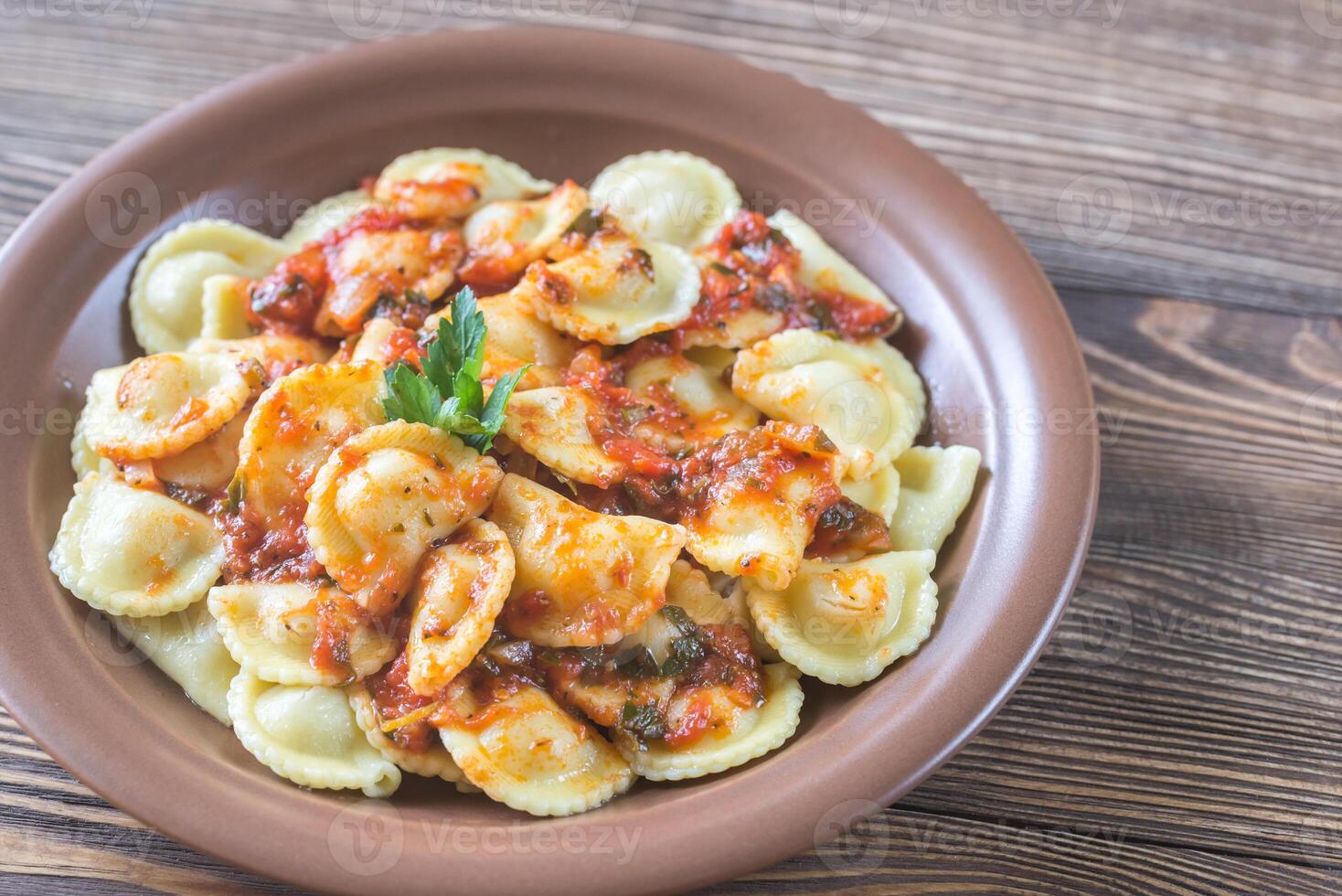 Portion of ravioli with marinara sauce photo