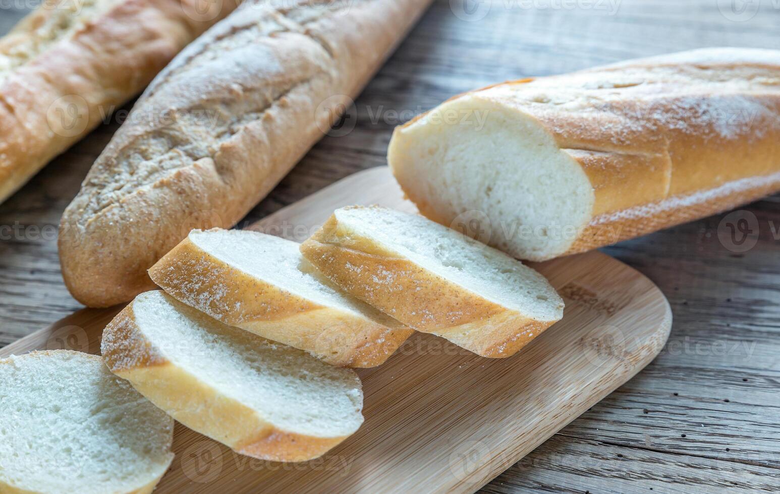 Three baguettes on the wooden background photo