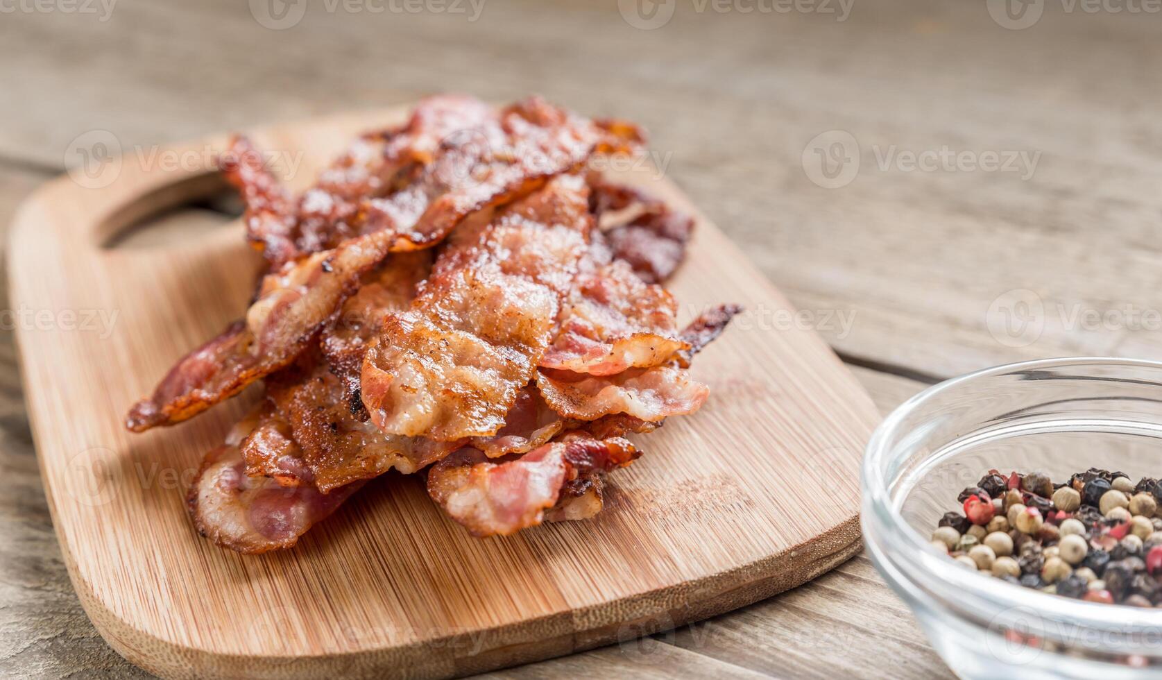 apilar de frito tocino tiras en el de madera tablero foto