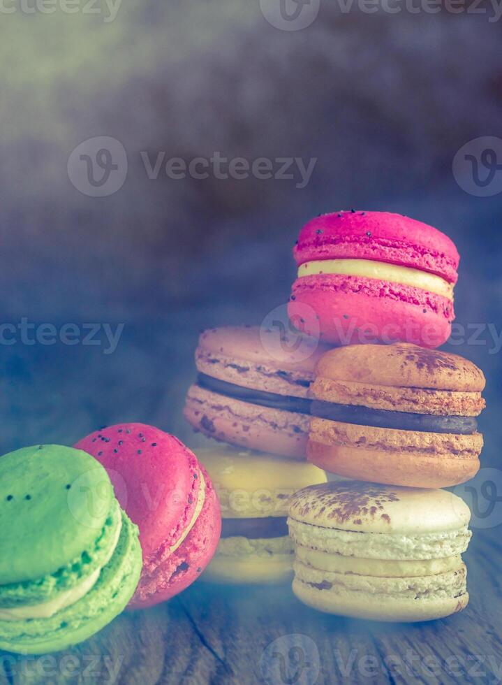 Colorful macarons on the wooden background photo