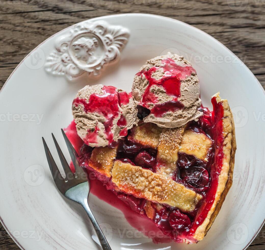 Slice of cherry pie with balls of chocolate ice cream photo