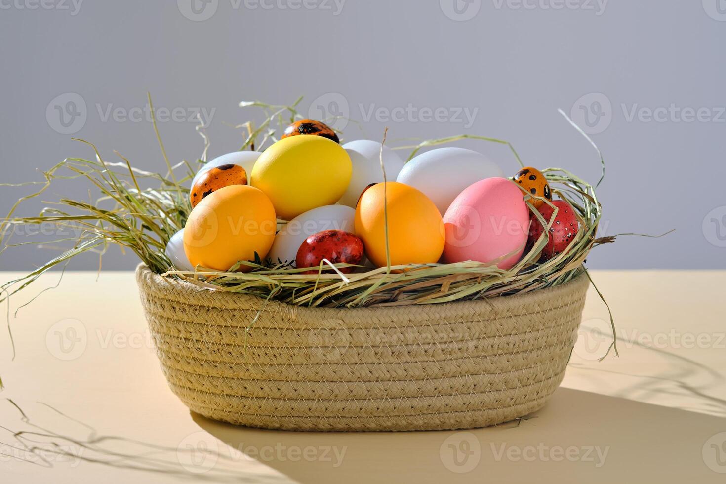 Easter colored eggs in a wicker basket. Easter composition. photo