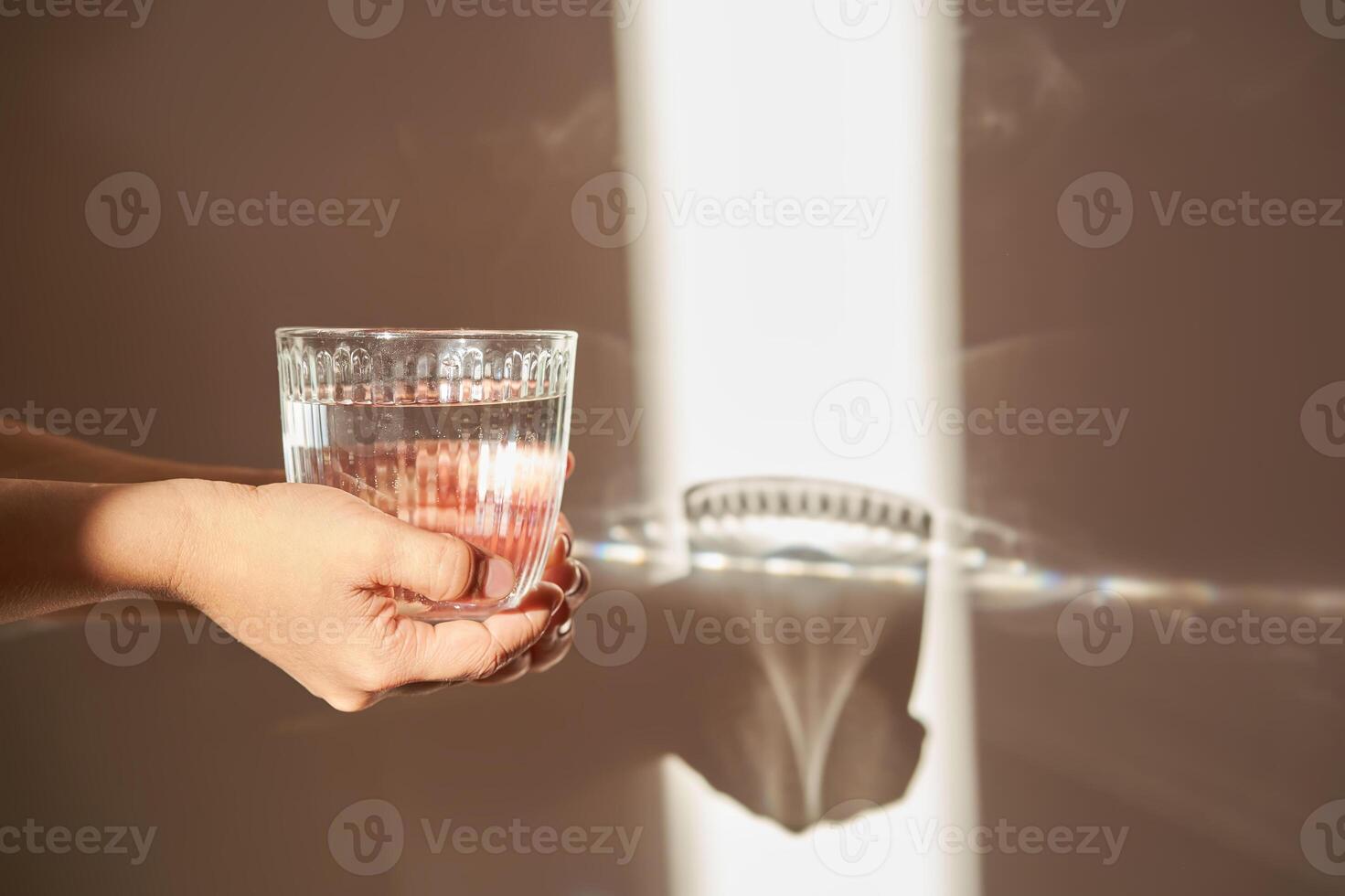 A glass of clean drinking water in the morning sun. photo