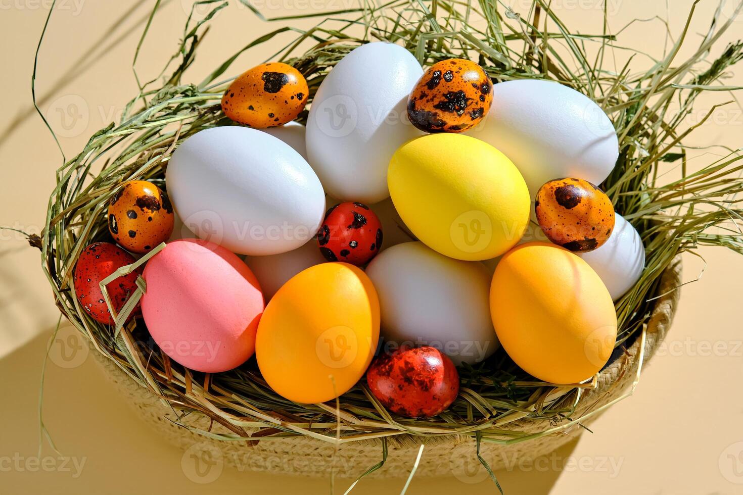 Easter eggs in pink, yellow and orange shades on a beige background. photo