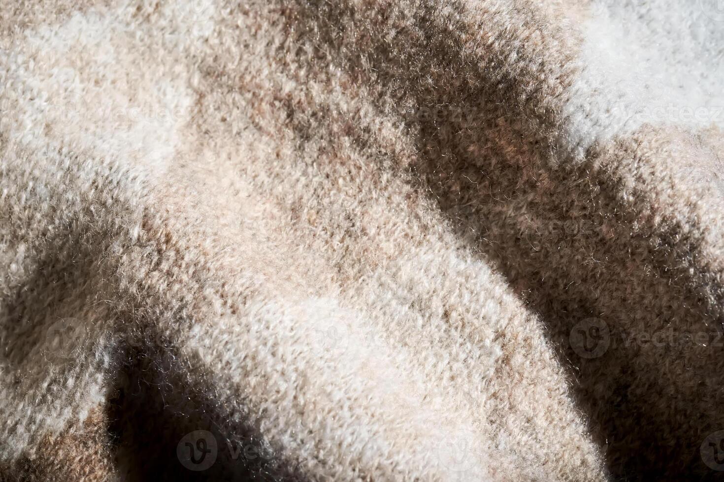 The texture of a warm sweater with a beige pattern. photo