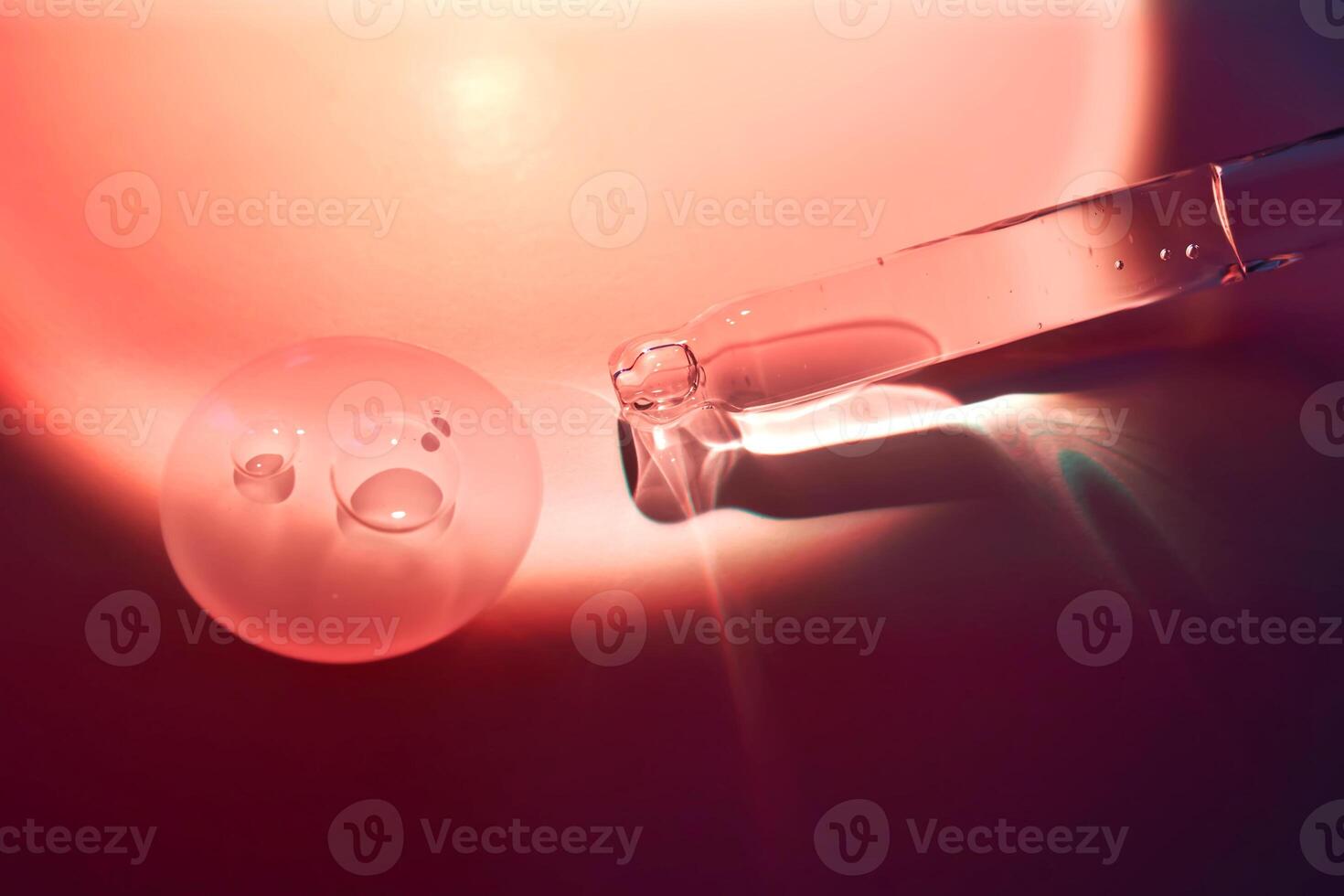 A dropper and a drop of sunscreen body serum in the orange sunset light. photo