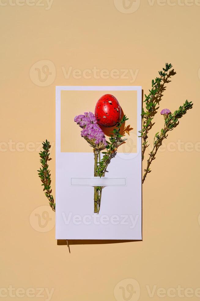 Easter card with a red quail egg on a beige background. photo