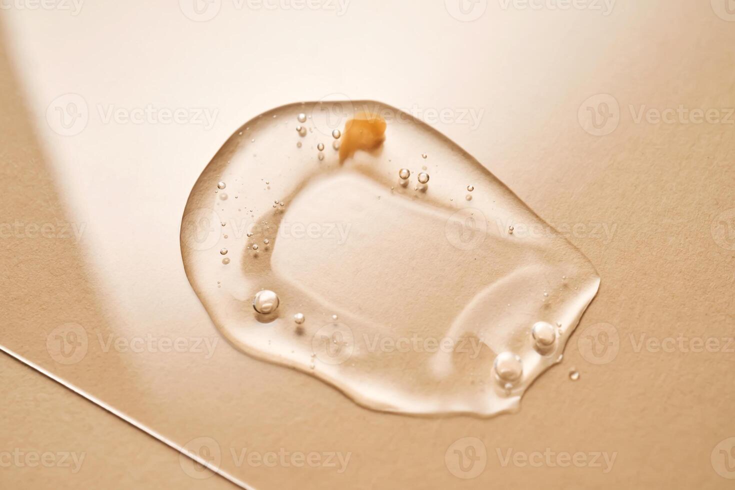 A drop of transparent cosmetic gel on a beige background. photo