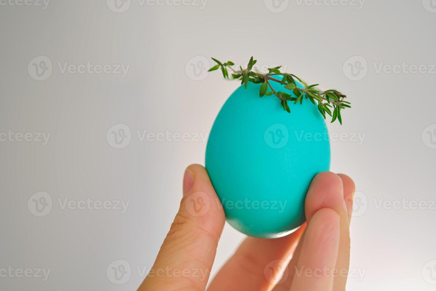 Turquoise Easter egg in hand close-up. photo