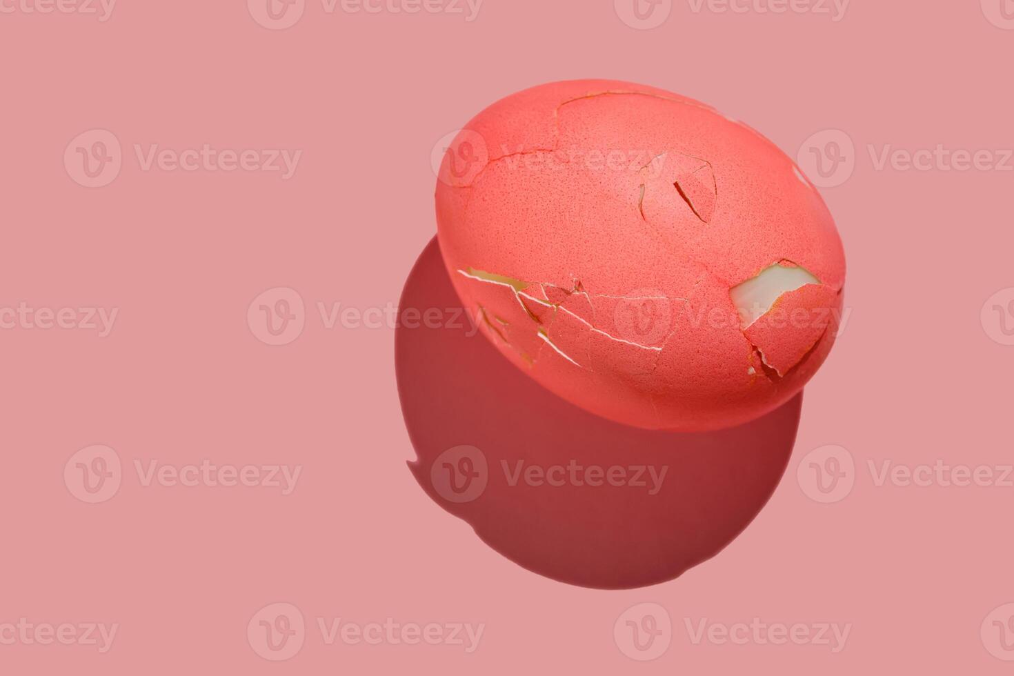 Cracked pink Easter egg on a pink background. photo