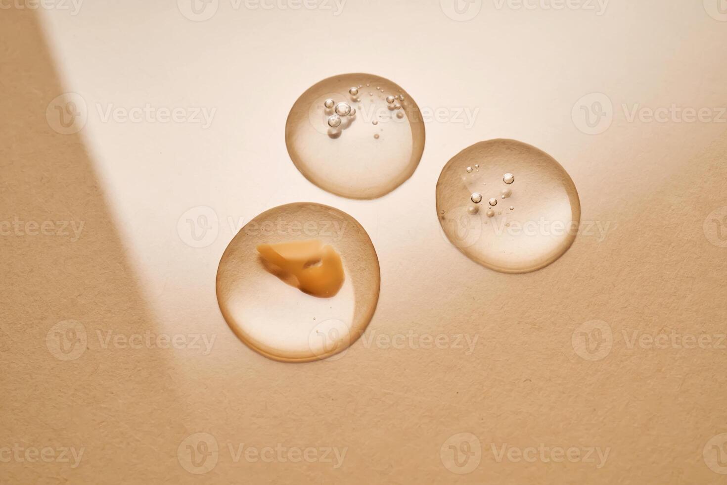 A drop of transparent cosmetic gel on a beige background. photo