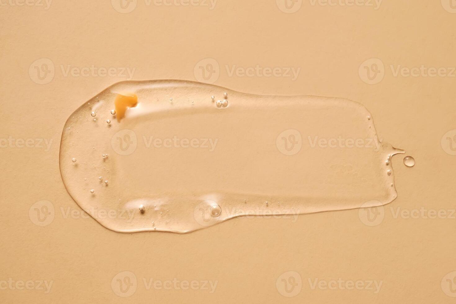 A drop of transparent cosmetic gel on a beige background. photo