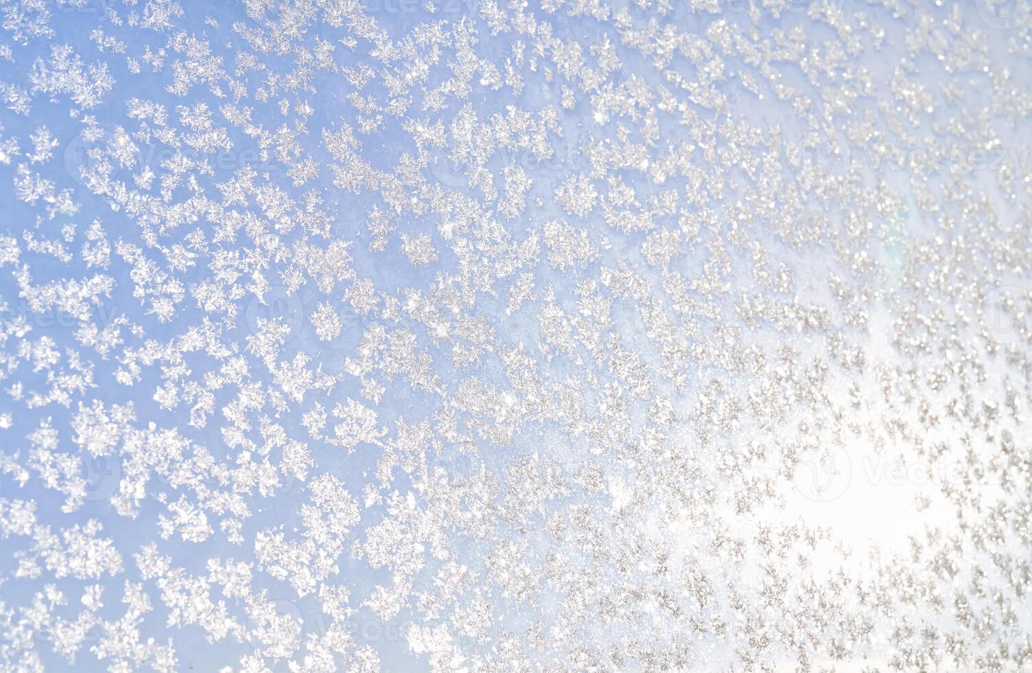 Abstract winter background. Frost on a frozen window against the blue sky. photo