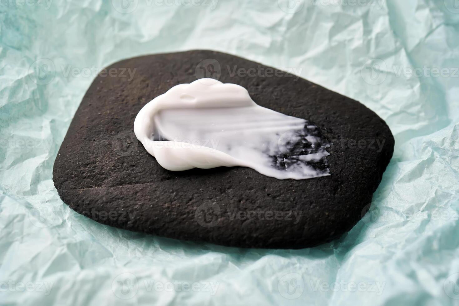 un frotis de blanco crema en un negro Roca. foto