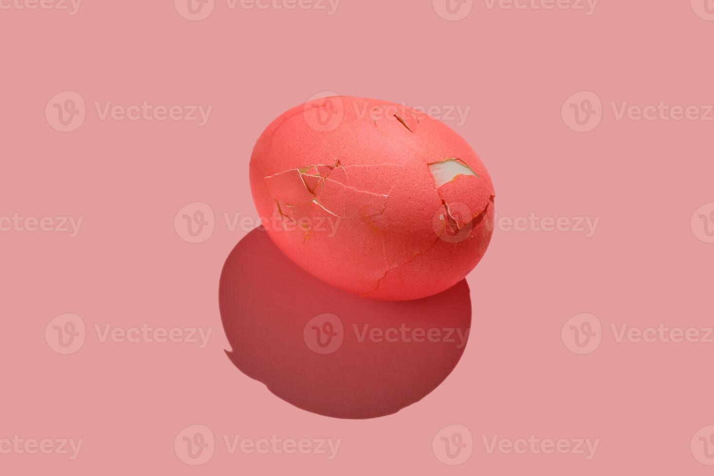 Cracked pink Easter egg on a pink background. photo