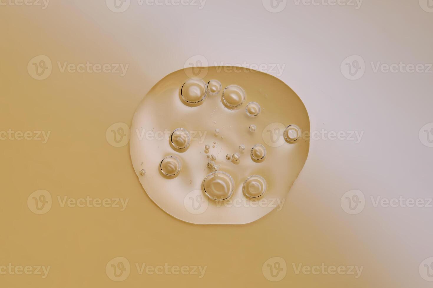 A drop of serum with bubbles on a beige nude background. photo