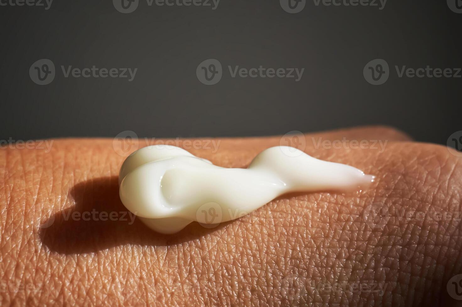 A smear of white moisturizer or sunscreen on a woman's hand. photo