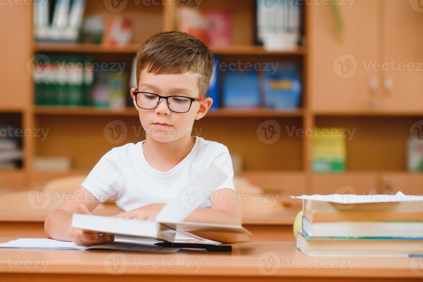 School boy in classroom at lesson photo