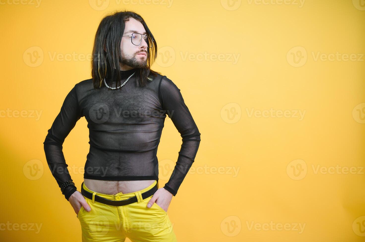 Young gay man is standing in the studio and posing for a camera. photo
