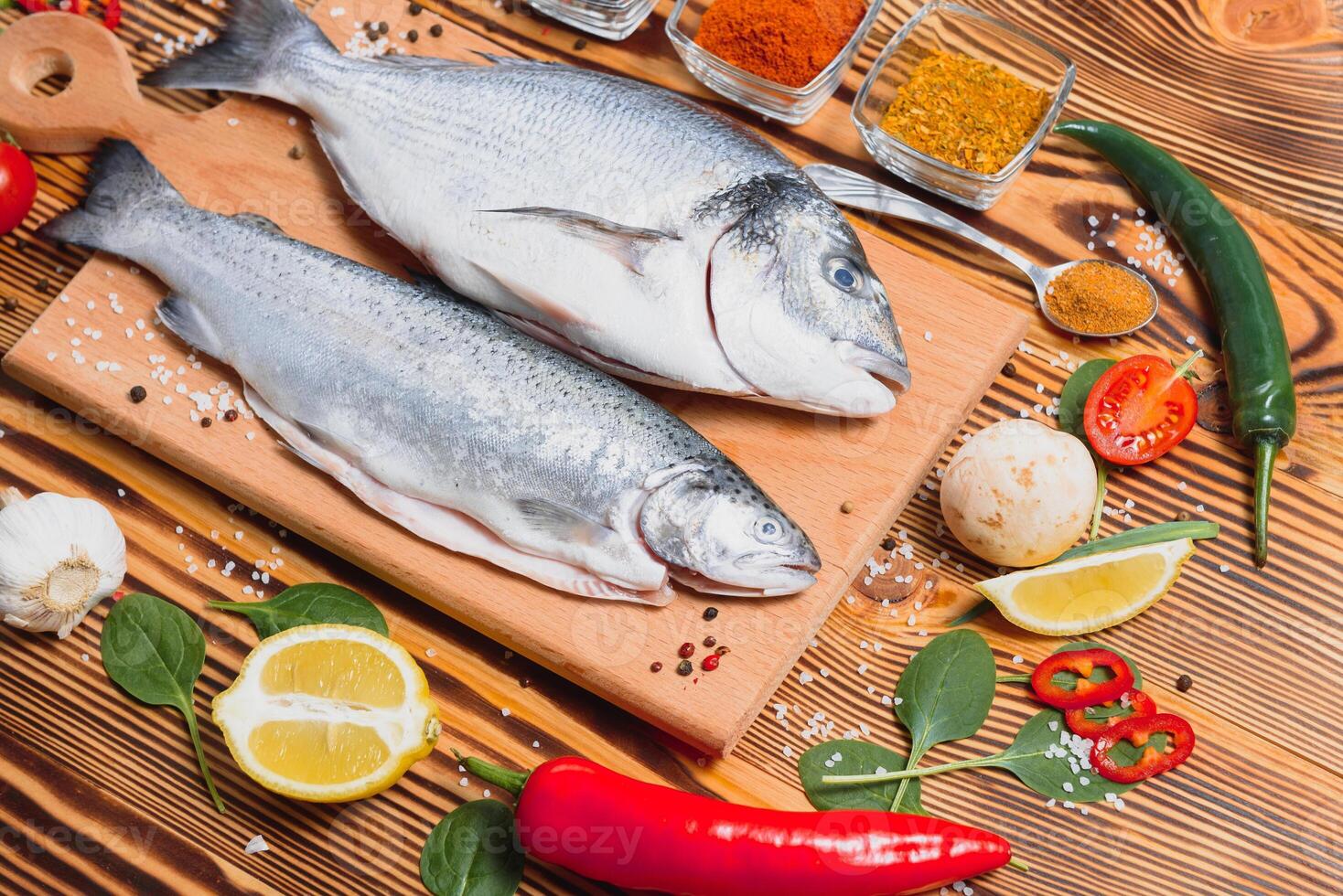 crudo dorado y trucha pescado con especias Cocinando en corte tablero. Fresco pescado dorado foto