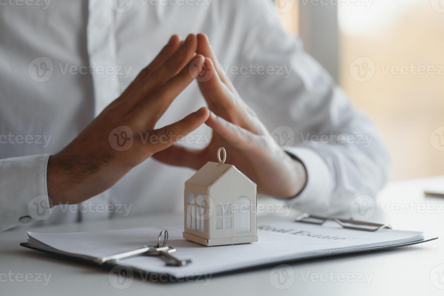 Close-up Of A Person Hand Signing Contract With Keys On It photo