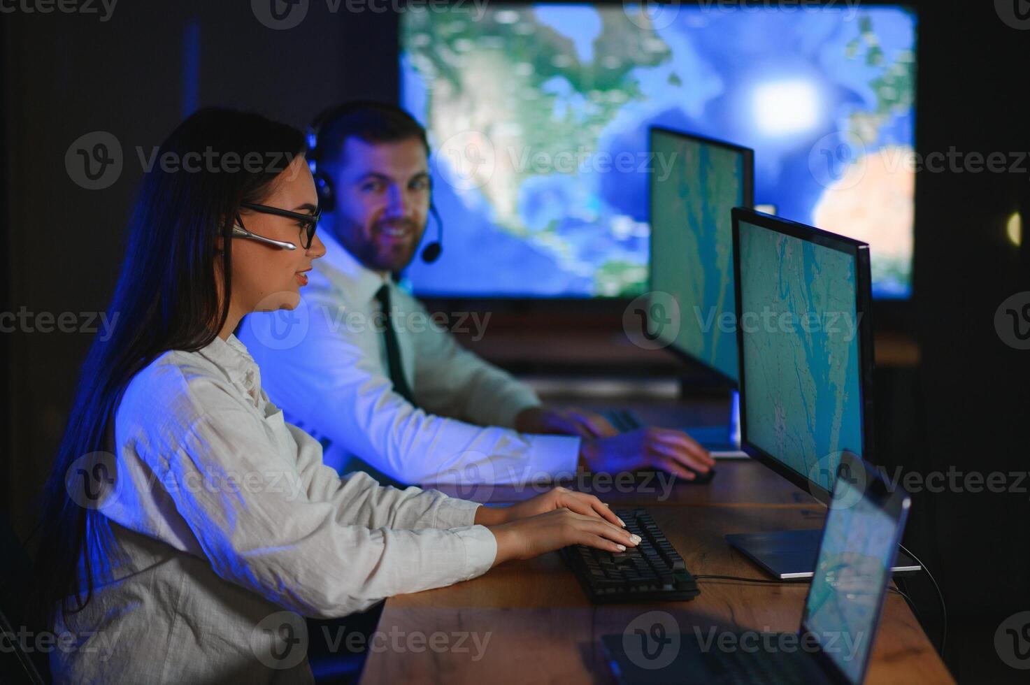 Center of dispatching maintenance. Portrait of cheerful woman and man working via headset microphone while sitting on navigation controller board photo