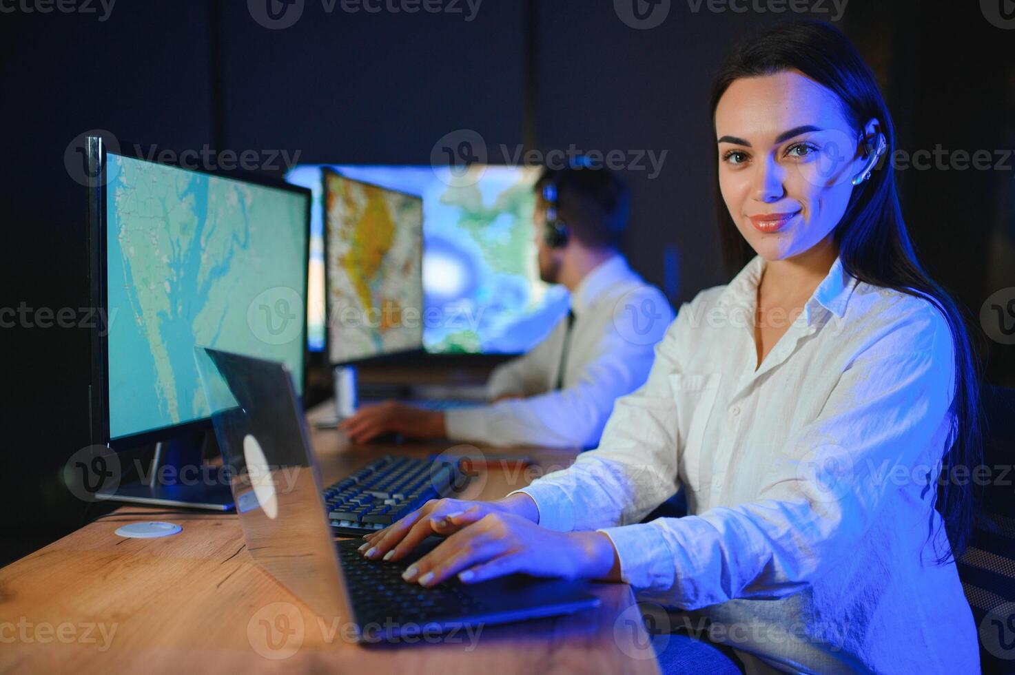 Friendly smiling woman call center operator with headset using computer at office photo