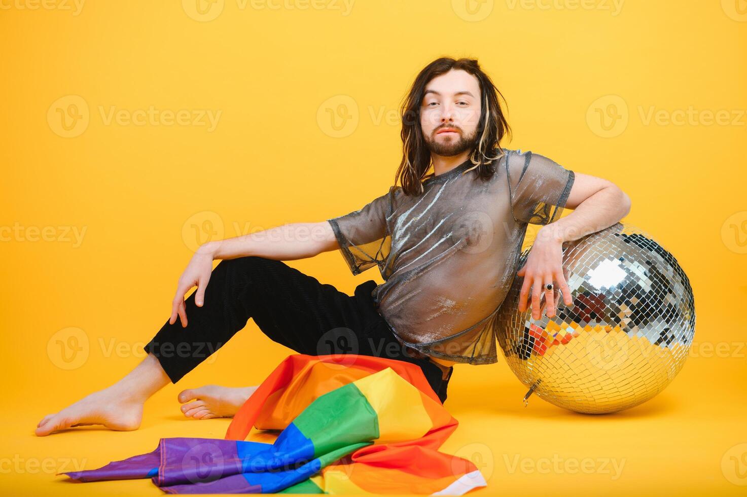 Young gay man is standing in the studio and posing for a camera. photo