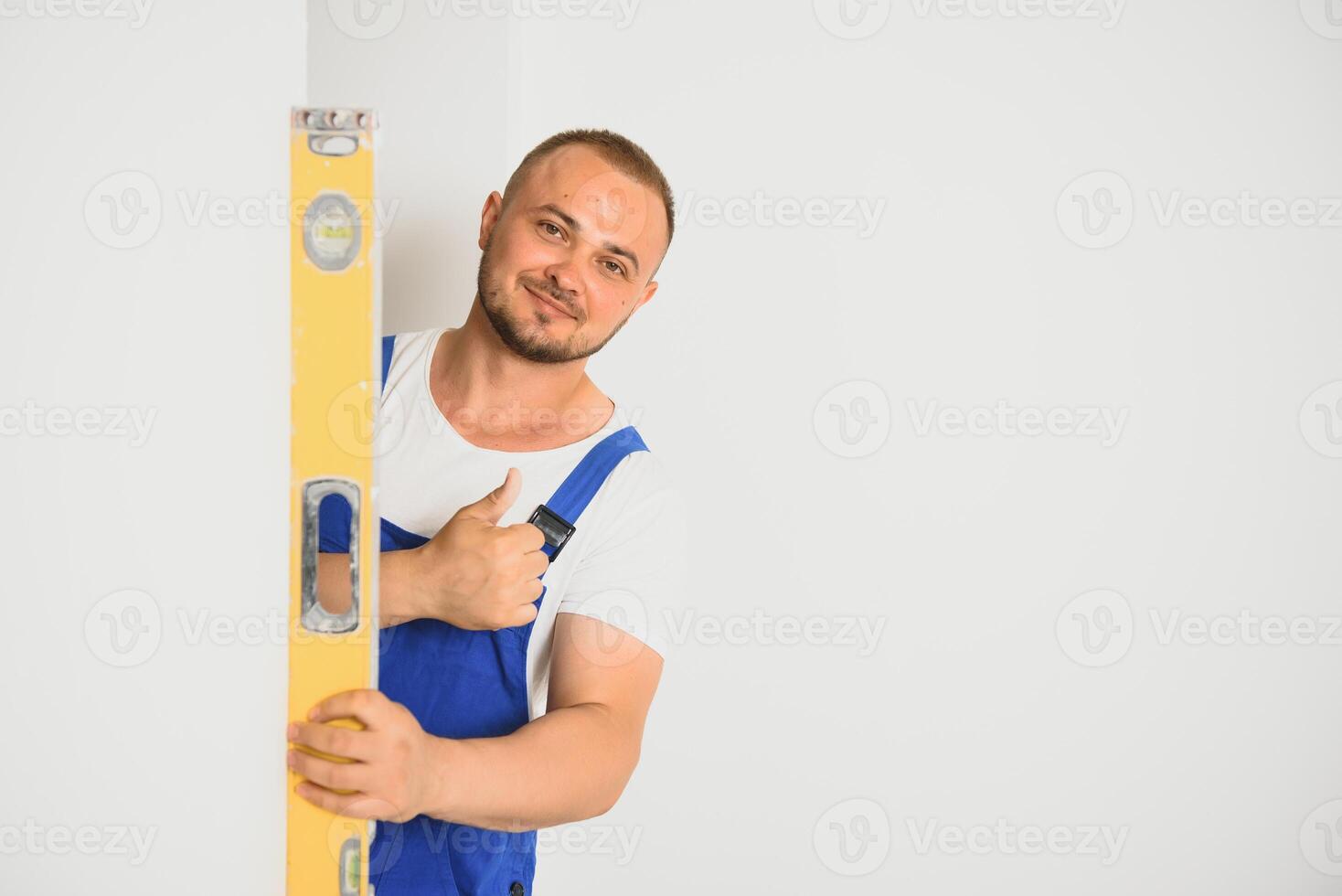 retrato de joven especialista haciendo pared avión en nuevo edificio foto