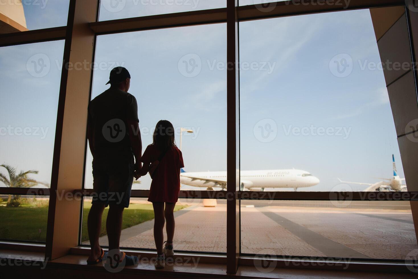 Exhausted father and daughter staying at the airport for a long time. Their flight was canceled. Copy space in right side photo